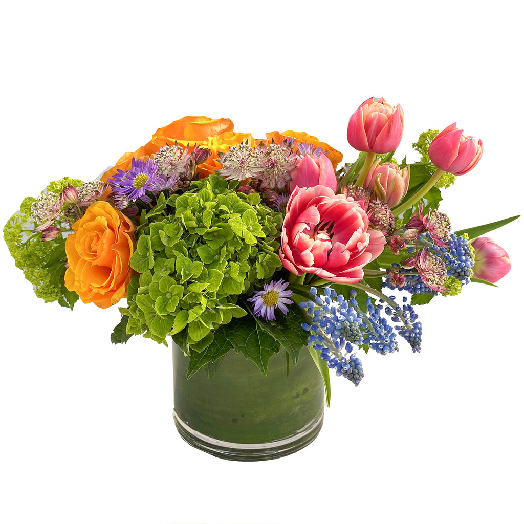 Radiant spring blooms such as hydrangea, tulips, and roses with seasonal greenery