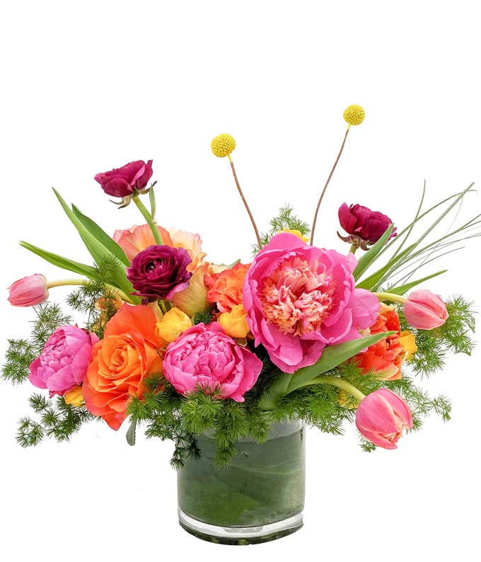 A stunning springtime arrangement of premium blooms such as peonies, roses, ranunculus, and tulips.