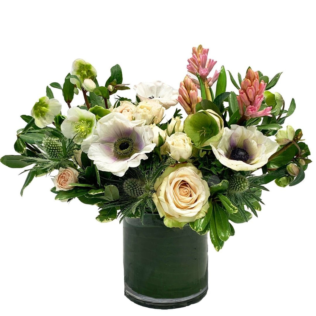 A lush garden-style arrangement elegantly designed with pink & cream colored premium blooms with modern greenery