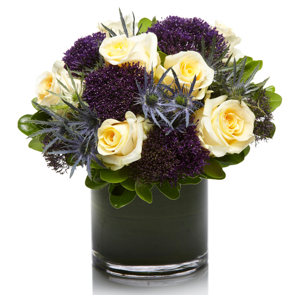 A Elegant Arrangement of Blue Thistle, Cream Roses and Purple Fillers - H.Bloom