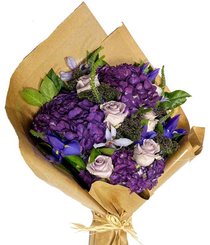 An elegantly wrapped bundle tied neatly together with fresh luxury purple and lavender blooms