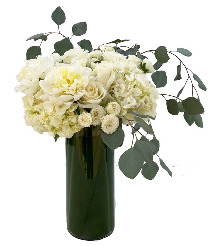 A tall and elegant arrangement of all-white blooms such as roses and hydrangea accented with eucalyptus.